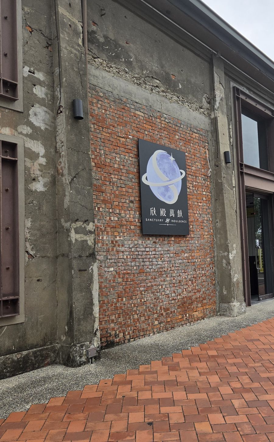 欣殿萬飲店門，紅磚牆與月亮招牌